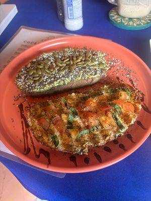 Sourdough toast with avocado and seeds and then hummus tomatoes, basil and balsamic   at Dushi Delicious  in Oranjestad
