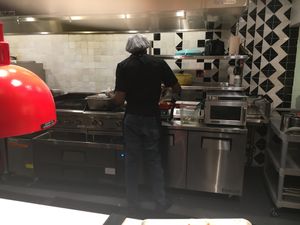 Server scooping the food to prepare the bowl (it takes only two minutes between when you order and when you are served) at Teranga - Midtown in New York City