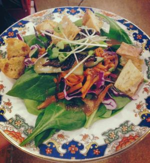 Spinach salad with shiitake bacon, house-made croutons and house dressing.
 at Red Emma's Bookstore Coffeehouse in Baltimore