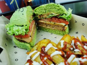 Cross section of a Jungle Burger with a side of Patatas Buenas. A very mellow and smoky burger, with added crunch from the crispy onions.  at Flower Burger in Brighton
