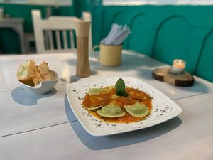 Ravioli, stuffed with spinach and riccotta cheese, seasoned with pesto or pomodoro sauce, served with oregano bread and Parmesan cheese. at Serendipia Encuentro in Salento