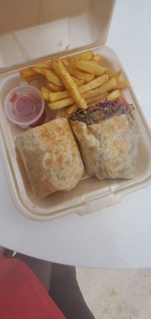 Vegan Wrap: coconut rice, black beans, cabbage, onions, tomato, and peppers with smoky chipotle vegan dressing at The Coconut Husk Restaurant & Beach Bar in Hopkins