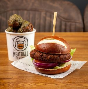 Mighty-Not-Meaty Balls with Pesto Sauce, and a Mighty-Not-Meaty Burger which is served in a Pretzel bun with salad and vegan cheese at The Meatball Company in Dover