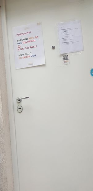 The door of the kitchen where you have to ring a bell to order at AhimSa Vega-Yoga in Belgrade