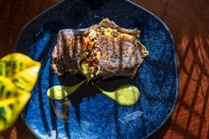 Gluten-free dough based on purple potato and oatmeal with spices, covered with
tarwi hummus, avocado stuffing, house pickles, sautéed sweet potatoes, marinated tofu and more. at Biofilia - Botánica Coffee House in La Paz