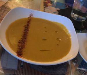 Smoked Farmers Collective Carrot and Split Pea Soup garnished with olive oil and smoked paprika.  at Fiction Kitchen in Raleigh