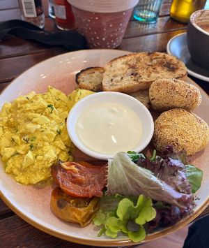 Vegan scrambled eggs with fried rice balls, grilled tomato, salad, toasted bread and spiced yogurt/cream 😋  at Cinnamon & Co in West End