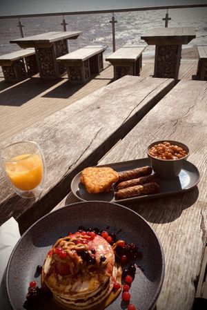 Pancakes with bis off sauce, frozen berries and americano with oat milk plus vegan sausage, hash browns and beans with glass of OJ 😋 what a treat.  at North Sea Observatory in Chapel St Leonards