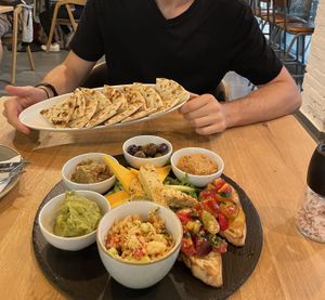 Starter sharing platter for 2 ❤️ (includes: hummus, baba ganoush, godly olives, mashed avocado, smoked tofu, cheese, unknown chunky dip, pita & bruschetta)  at Vegan Garden Budapest in Budapest