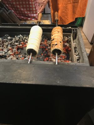 Vegan chimney roasting over coals - one with choc chips and the other with sugar and cinnamon cooking away. at Vegan Garden Budapest in Budapest