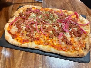 Pinsa con mozzarella y boloñesa veganas  at LaMundi in Cordoba