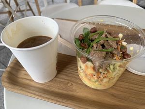 Cold Americano with oat mylk and a pad thai salad.   at Wild & The Moon - Ave de Champs Elysées in Paris