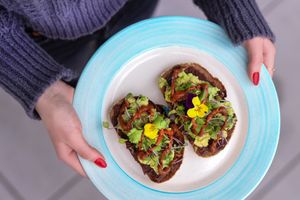 Mexican toast served on organic local gluten free bread with house-made mole sauce, spiced black bean mash, avocado and greens at Elixir De La Lune in La Jolla