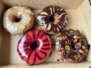 Clockwise from top left: vanilla espresso, Boston cream, chocolate with coconut 'bacon', strawberry blueberry at Dough House Vegan Donuts in Black Mountain