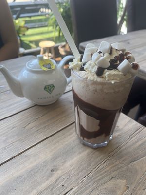 A pot of lemon and ginger tea with a chocolate and peanut butter milkshake .  at Vemillion in Basingstoke