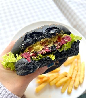 Avocado burger: special burger patty, topped with avocado, tomato, pickles, onion and cashew sauce in a brown bread bun at Future Diner in Yerevan
