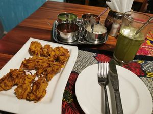 Onion Pakora, dips (mint, tamarind, coconut, and spicy I don't know what), and a lemon mint juice at Harbour Kitchen in Zanzibar
