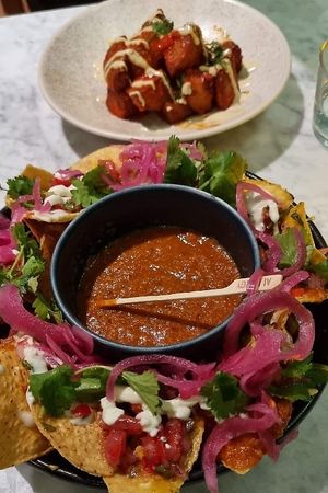 Harissa patatas bravas with tahini cream + Nachos with black bean mole, charred salsa roja, pink pickled onion at Mildreds - Covent Garden in London