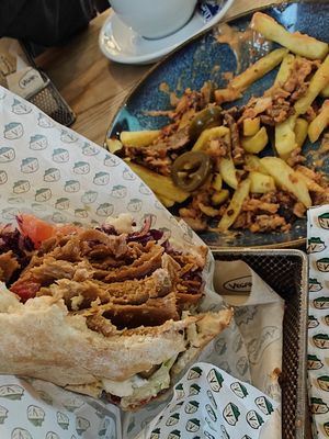 Loaded Fries in the background  💕 + big bite of Veganitas Berlin K'Bab, you'll get full! at Veganitas in Zurich