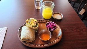 Pineapple Lemon Ginger juice, breakfast burrito, Habanero Carrot hot sauce, pickled cabbage at Soluna Cafe in Jackson