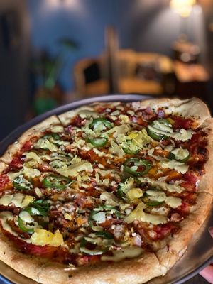 luau pizza with bacon, pineapple sauerkraut, jalapeños, sweet jalapeno aioli, and cheeze, with san Marzano tomato sauce at The Attic Bar & Stage in Calgary