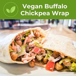 Roasted chickpeas, tomatoes, shredded carrots, sliced red onion and romaine lettuce in a wrap the a vegan buffalo aioli. at The Café in Little Falls