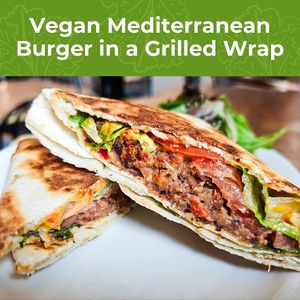 Vegan burger of black beans, garbanzo beans, roasted red peppers and artichoke hearts grilled in a tortilla fold with lettuce, tomatoes and vegan sundried tomato aioli. at The Café in Little Falls