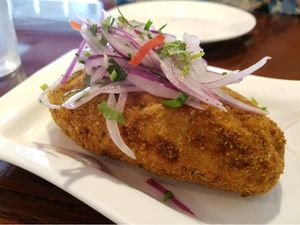 Papa Rellena: Crispy Mashed Potato stuffed with Vegetarian Meat, topped with Julienned Red Onions at Aji Peruvian Restaurant in Ooltewah