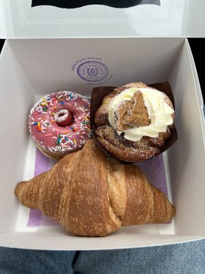 Vanilla/berry cake (top left), cinnamon roll (top right), plain croissant (bottom)   at Purple Horseshoe Baking in Oakville