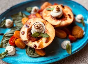 Grilled peaches with herb ricotta, basil, cherry tomatoes and balsamic  at The Sweet Botanist Plant Based - Cloud Kitchen in Dallastown