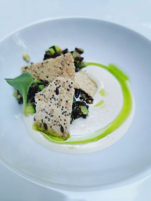 Entrée di benvenuto con crema di anacardi, crackers, riso venere e zucchine con olio al basilico at Caffè Tomaso in Udine