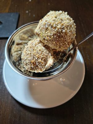 Mozart Eisknödel
Hazelnut-chocolate ice cream balls filled with marzipan, pistachio cream covered in caramelised hazelnut crumbs. at Tisch in Vienna