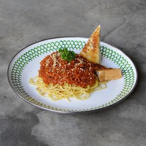 Angel Hair Bolognese: soy bolognese pasta sauce topped with cashew parmesan cheese and fresh parsley, served with garlic bread slices | cal: 437, protein: 20g, carb: 70g, fat: 9g at Warung Dua Hati in Canggu
