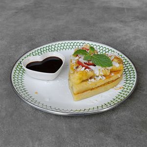 Protein Pancakes: heart-shaped pancakes infused with plant-based protein powder, topped with strawberry, caramelized banana, coconut flakes, served with coconut nectar at Warung Dua Hati in Canggu
