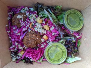 Classic Falafel on mixed greens with tabouli, pickled red cabbage, carrot chickpea salad, & spicy green sauce at Amsterdam Falafel & Kabob in Omaha