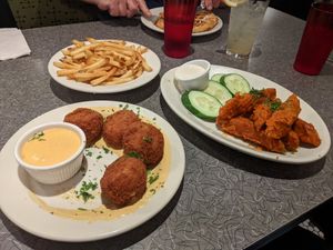 Mac and cheese balls, buffalo tenders, fries, and waffle in the background at Veggie Galaxy in Cambridge