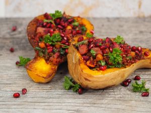 Roasted stuffed Butternut squash with harissa spiced quinoa and sauteed vegetables topped with pomegranate at Spoon and Sprout in Houston
