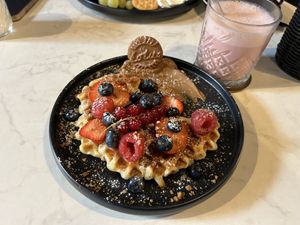 Vegan waffle with fresh berries and lotus cream accompanied by the Pink super drink  at Universe Cafe in Mannheim