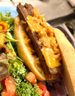 Grilled sausage. Gluten free house made bun, white beens house made sausage, house made adobo sauce, caramelized red bell pepper and onion, kimchi.  at Botanika Cafe in Ridgefield