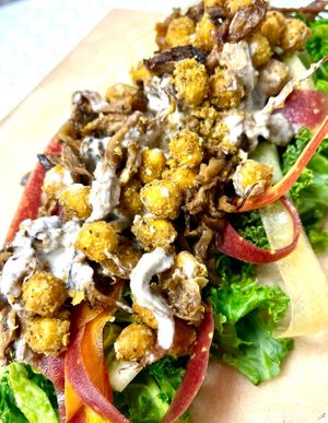 Caesar wrap. Kale, lettuce, rainbow carrots, baked spicy chickpea, pulled mushrooms, cashew parmesan , house made Caesar dressing and cassava wrap   at Botanika Cafe in Ridgefield