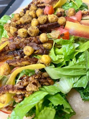 TEMPEH CAESAR WRAP. HM smoked tempeh, crispy lettuce, kale, chickpea, tomato, rainbow carrots,delicious caesar dressing, gluten free wrap, cashew parmesan.  at Botanika Cafe in Ridgefield