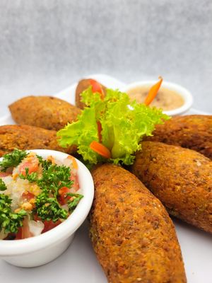 Special combo of 6 Vegan Kibbe crispy falafel tempura stuffed with vegetables, served with tabbouleh salad and smoked baba ganoush cream. at Domi Food Catering in Bogota