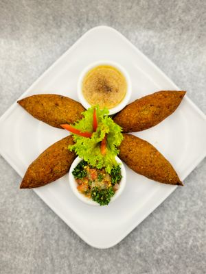 Special combo of 4 Vegan Kibbe crispy falafel tempura stuffed with vegetables, served with tabbouleh salad and smoked baba ganoush cream. at Domi Food Catering in Bogota