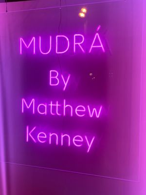 The sign outside letting you know you have found the restaurant at MUDRA Plant Based  in Madrid