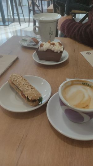 Café amb llet de civada, entrepà d'hummus, tomàquets secs, canonges i formatge cremós vegà i pastís de pastanaga 🤤🤤🤤 at La Veggiesseria in Tarragona