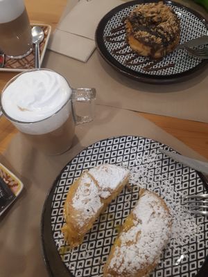 Amazing bola de berlim (tradicional and the egg cream is so accurte) and whipped cream latte 🤤 at Guará in Vila Nova De Gaia