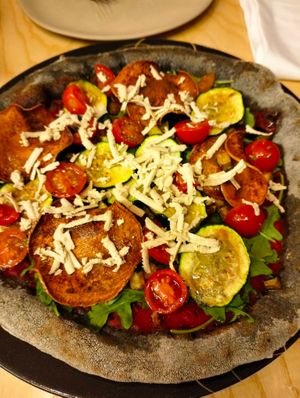 amazing pizza with charcoal dough, tomato sauce, rocket, crunchy sweet potatoes, zucchini, cherry tomatoes and homemade cashew cheese. at La Gastrobottega Di Giuseppe in Calpe