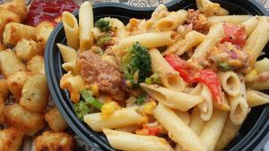 Custom mac bowl with gluten-free pasta, Beyond Sausage, veggies, vegan cheese sauce and melted vegan cheese slices. Side of tater tots. at I Heart Mac & Cheese in Naples