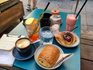 Pain au chocolat, cinnamon roll, flat white, blood orange lemonade, pink velvet latte on ice at Cafe Lozzi in Munich