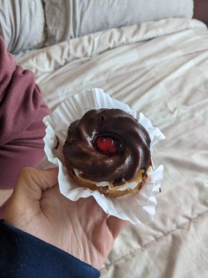 Vegan "swirl" donut with whipped cream middle, chocolate frosting on top, and cherry jam at Haven On Earth Bakery & Deli in Reno